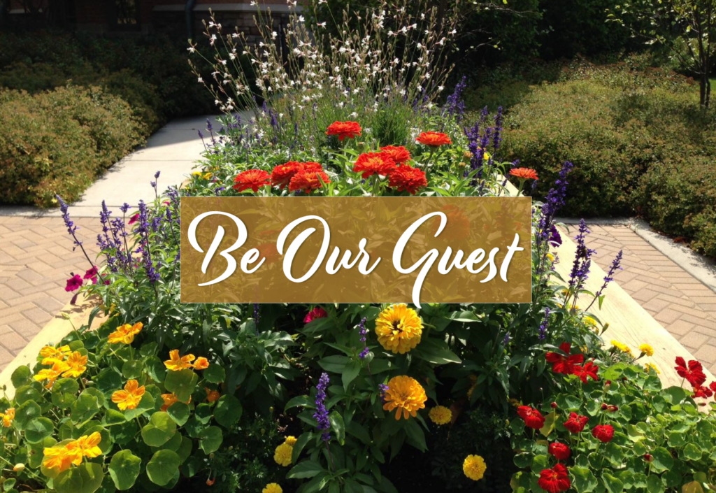 A garden at The Garlands with the words Be our Guest